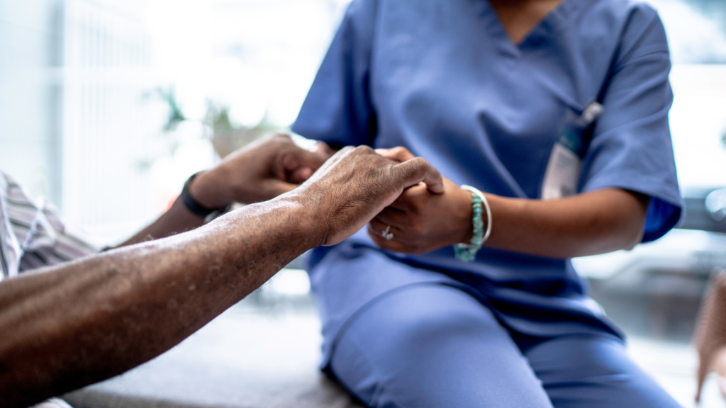 a nurse holding the hand of a patient